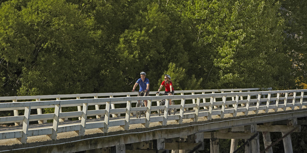 bikers crossing a bridge in southland nz