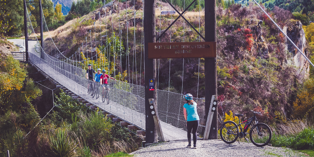 Around the Basin Bike QT tour group going across a swing bridge