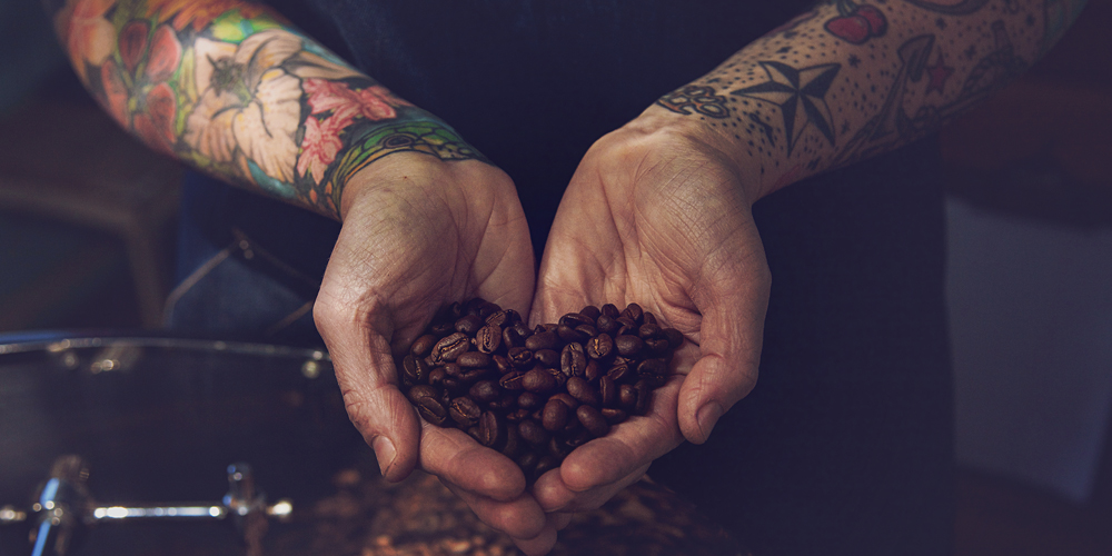 ROAR Coffee man holding coffee beans