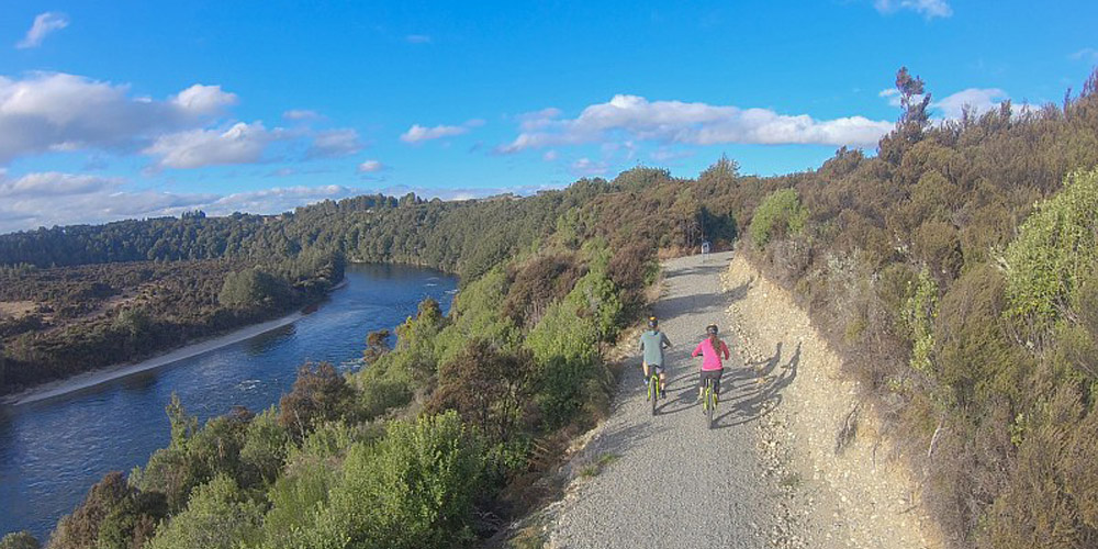 Bike Fiordland riders alongside the river