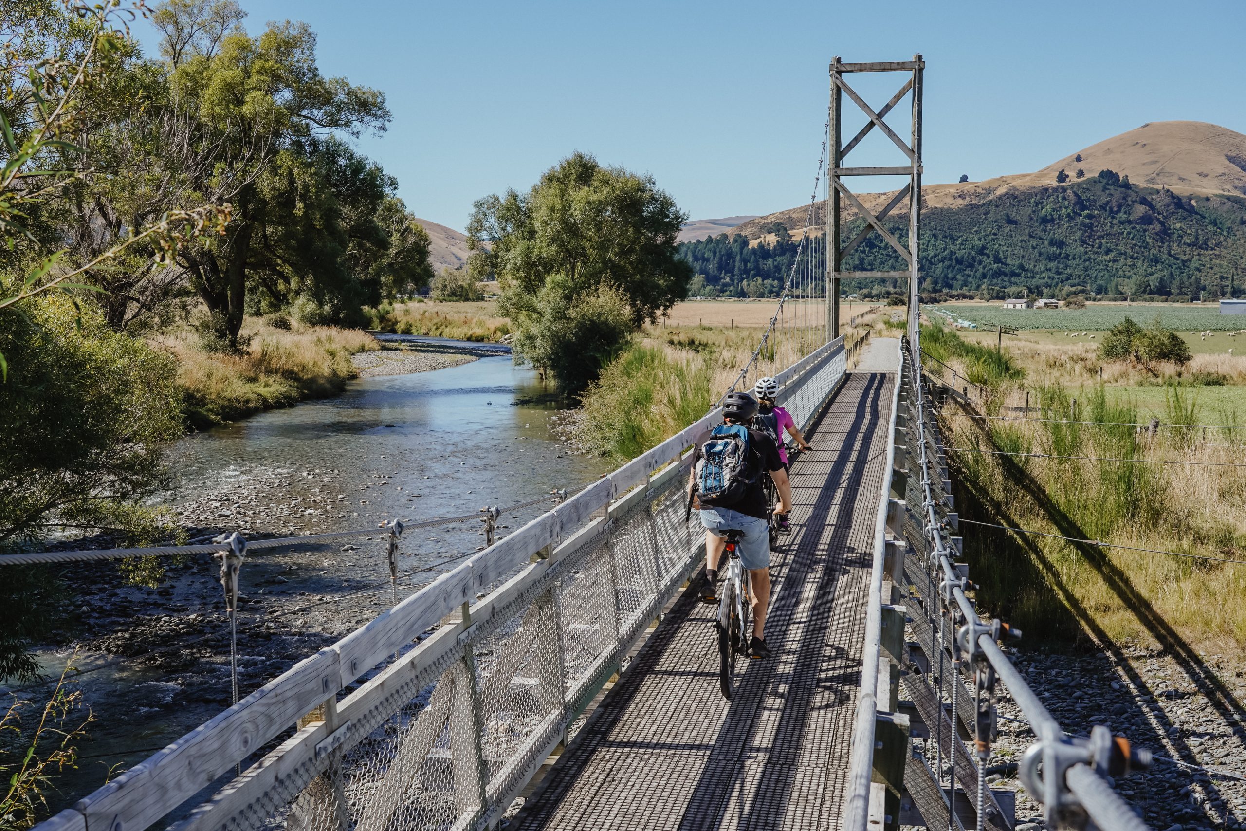 biker crossing a bridge at Around the Mountains Cycle Trail